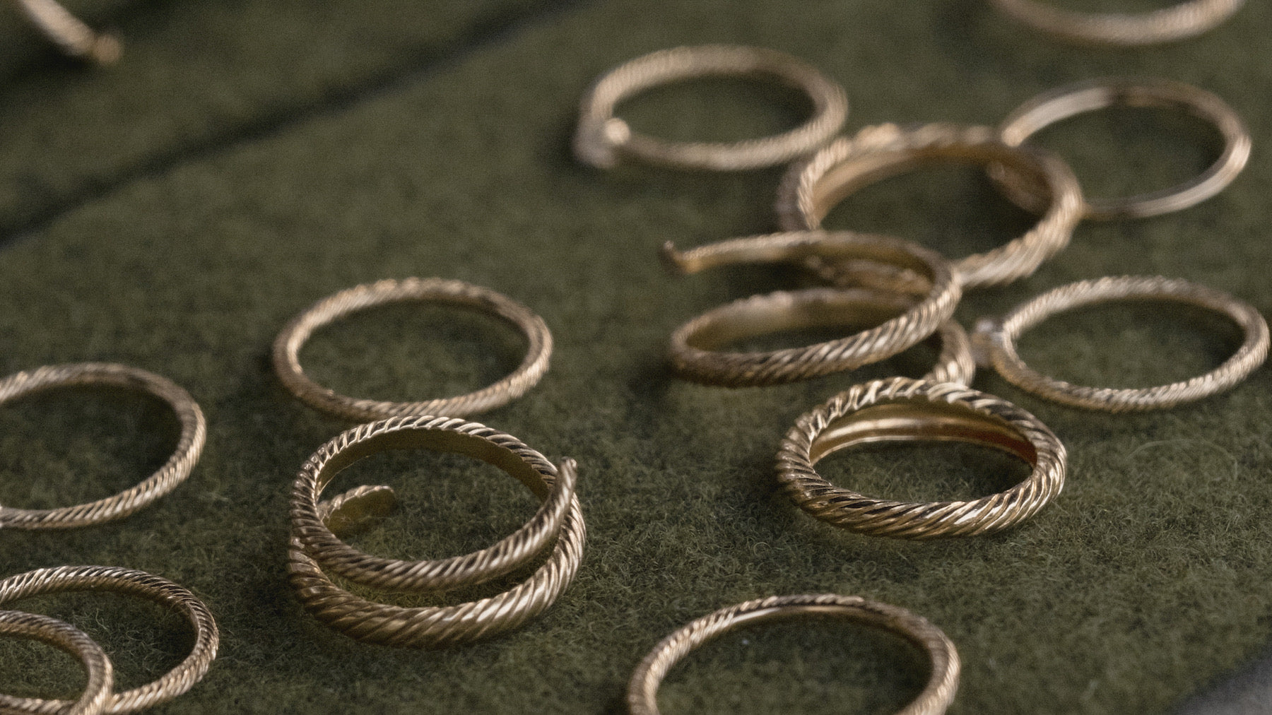 Banyan texture rings on green felt, the material language before it reaches the screen