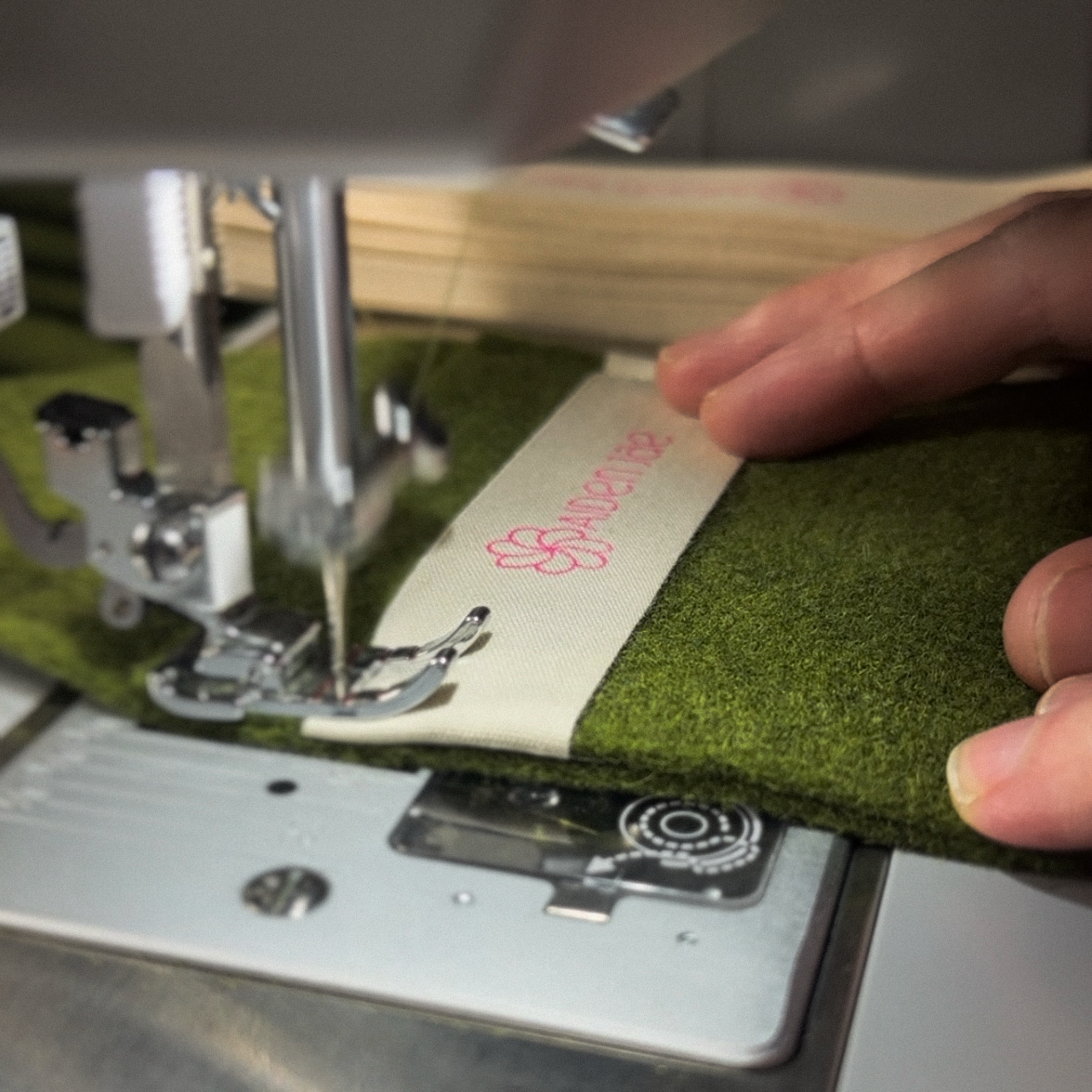 Custom wool jewelry pouch being sewn, sustainability as operational detail, not marketing claim